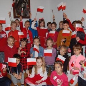 [zdjęcie-młodzi uczestnicy warsztatów "Symbole Narodowe" zorganizowanych w Ośrodku Edukacji Regionalnym w Starym Wiśniczu prezentujący wykonane przez siebie biało-czerwone flagi]